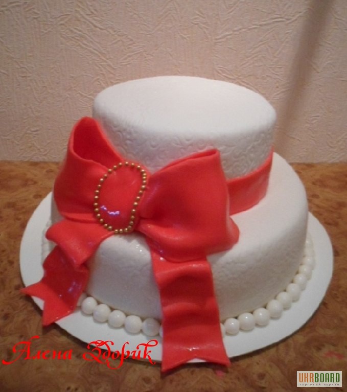 Фото 3. Свадебный белый 2-х ярусный торт с большим красным бантом