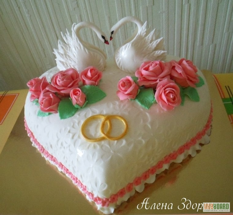 Свадебный торт в виде сердца с лебедями и кольцами