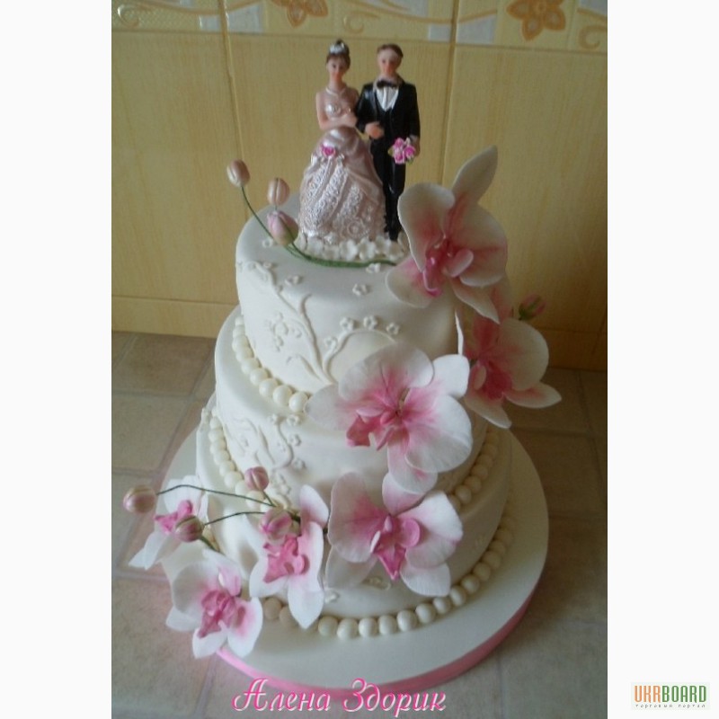 Фото 2. Свадебный торт с белыми орхидеями фаленопсис, узорами и статуэткой жениха и невесты
