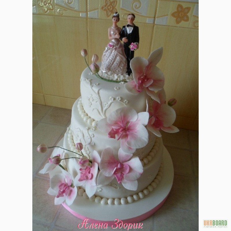 Фото 3. Свадебный торт с белыми орхидеями фаленопсис, узорами и статуэткой жениха и невесты
